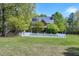 Sprawling green backyard featuring the rear of the home enclosed by a white picket fence with mature trees at 8120 Stillbreeze Dr, Fuquay Varina, NC 27526