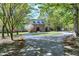 Traditional two-story brick home featuring a circular driveway, mature trees, and lush landscaping at 8120 Stillbreeze Dr, Fuquay Varina, NC 27526