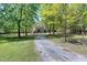 Brick home on a large wooded lot, showcasing the spacious driveway and manicured lawn at 8120 Stillbreeze Dr, Fuquay Varina, NC 27526