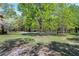 Picturesque front yard showcasing mature trees and a winding driveway at 8120 Stillbreeze Dr, Fuquay Varina, NC 27526