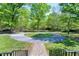 Beautifully landscaped circular driveway and grounds with mature trees and brick pathway at 8120 Stillbreeze Dr, Fuquay Varina, NC 27526