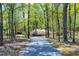 Lush grounds showing paved driveway with flowering azalea bushes along the side and an abundance of trees at 8120 Stillbreeze Dr, Fuquay Varina, NC 27526