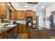 Traditional eat-in kitchen features wood cabinets, stone countertops, stainless steel appliances, and hardwood floors at 8120 Stillbreeze Dr, Fuquay Varina, NC 27526