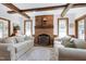 Inviting living room featuring exposed wood beams, brick fireplace, and two comfortable sofas at 8120 Stillbreeze Dr, Fuquay Varina, NC 27526