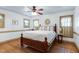 A well-lit main bedroom features hardwood floors, a ceiling fan, three windows, and a queen bed at 8120 Stillbreeze Dr, Fuquay Varina, NC 27526
