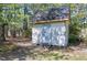 Exterior view of the storage shed featuring a single door, roof, and surrounded by greenery at 8120 Stillbreeze Dr, Fuquay Varina, NC 27526