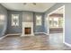 Spacious living room with a fireplace, bright windows, neutral gray paint, and modern laminate flooring at 813 S Franklin St, Rocky Mount, NC 27803