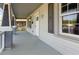 Inviting covered porch with gray flooring, white railings, and stylish architectural columns at 813 S Franklin St, Rocky Mount, NC 27803