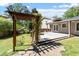 View of a well-maintained backyard with a wooden deck, a pergola covered in greenery, and ample space for outdoor activities at 904 Emory Ln, Raleigh, NC 27609