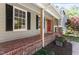 Inviting front porch with a brick floor and a vibrant red front door at 904 Emory Ln, Raleigh, NC 27609