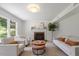 Inviting living room with neutral furniture, a brick fireplace, and a large window providing natural light at 904 Emory Ln, Raleigh, NC 27609