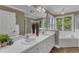 Bathroom featuring a double sink vanity, large mirror, and a bathtub surrounded by windows for natural light at 1005 Thorncroft Ln, Apex, NC 27502