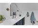 Stylish bathroom vanity with an arched mirror, white quartz countertop, and navy blue cabinets with gold hardware at 1005 Thorncroft Ln, Apex, NC 27502