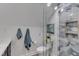 Modern bathroom featuring a glass enclosed shower with marble tiling and built-in shelving, with towels on display at 1005 Thorncroft Ln, Apex, NC 27502