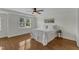Comfortable bedroom featuring a ceiling fan, a large window, hardwood floors, and a tray ceiling at 1005 Thorncroft Ln, Apex, NC 27502
