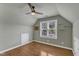Cozy bedroom featuring hardwood floors, a ceiling fan, a bright window, and neutral-colored walls at 1005 Thorncroft Ln, Apex, NC 27502