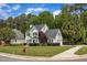Charming two-story home with lush landscaping, mature trees, and a well-manicured lawn at 1005 Thorncroft Ln, Apex, NC 27502