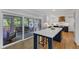 Modern kitchen with white cabinetry, a large center island, and access to the screened-in porch at 1005 Thorncroft Ln, Apex, NC 27502