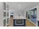 Kitchen island featuring a stainless steel oven, seating, and an adjacent screened-in porch at 1005 Thorncroft Ln, Apex, NC 27502