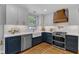 Beautifully renovated kitchen with white cabinets, marble backsplash, stainless steel appliances, and wooden accents at 1005 Thorncroft Ln, Apex, NC 27502