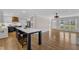 An open floor plan shows the kitchen and living room, with a center island separating the spaces and wood flooring at 1005 Thorncroft Ln, Apex, NC 27502