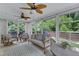 Bright sunroom featuring many windows, leaf fans, and cozy neutral-toned furniture with a view of the backyard at 1005 Thorncroft Ln, Apex, NC 27502