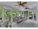 Bright sunroom with multiple windows, ceiling fans, and comfortable seating at 1005 Thorncroft Ln, Apex, NC 27502