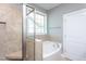 Bright bathroom showcasing a tiled shower with a built-in seat and a separate soaking tub at 1007 Fairhaven Dr, Mebane, NC 27302
