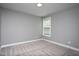 Bedroom featuring neutral walls, plush carpeting, and a window view to enhance the room's appeal at 1007 Fairhaven Dr, Mebane, NC 27302