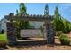 The community entrance sign reads 'Courtyards at Magnolia Glen' and includes manicured landscaping and a stone column structure at 1007 Fairhaven Dr, Mebane, NC 27302