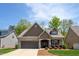 Charming home with brick and shingle exterior, a well-kept lawn and a two car garage at 1007 Fairhaven Dr, Mebane, NC 27302