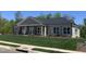 New construction home featuring a stone facade, a well-maintained lawn, and ample windows for natural light at 1007 Fairhaven Dr, Mebane, NC 27302