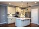 Spacious kitchen with white cabinets, stainless steel appliances, marble countertops, and a central island at 1007 Fairhaven Dr, Mebane, NC 27302