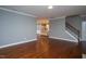 Open-concept living room with hardwood floors leading to a kitchen and staircase at 1007 Fairhaven Dr, Mebane, NC 27302