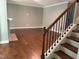 Open living room area with gleaming hardwood floors and a classic staircase at 1007 Fairhaven Dr, Mebane, NC 27302