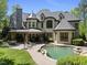Expansive backyard featuring an in-ground pool, stone patio, fireplace, and lush landscaping at 1009 Linenhall Way, Wake Forest, NC 27587