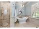 Relaxing bathroom with a soaking tub, a walk-in shower, and a travertine tile floor at 1009 Linenhall Way, Wake Forest, NC 27587