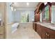 Luxurious bathroom with a standalone tub, custom vanity, and natural light from a window at 1009 Linenhall Way, Wake Forest, NC 27587