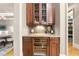 Butler's pantry with custom cabinetry, a wine fridge, and granite countertops at 1009 Linenhall Way, Wake Forest, NC 27587