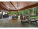 Inviting covered patio with comfortable seating, ceiling fans, and outdoor dining area at 1009 Linenhall Way, Wake Forest, NC 27587