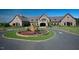 Stone clubhouse with a circular driveway and well-manicured landscaping offers a luxurious entrance at 1009 Linenhall Way, Wake Forest, NC 27587