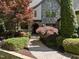 Stunning home exterior boasting stone accents, mature trees, and a well-maintained walkway at 1009 Linenhall Way, Wake Forest, NC 27587