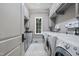 Well-lit laundry room featuring front-loading machines, built-in cabinetry, and granite countertops at 1009 Linenhall Way, Wake Forest, NC 27587