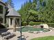 Resort-style swimming pool with a slide and jacuzzi, surrounded by lush landscaping and a beautiful stone deck at 1009 Linenhall Way, Wake Forest, NC 27587