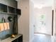 Mudroom area upon entry with a dark built-in shelf, bench, and light-colored flooring at 109 S Plum St, Durham, NC 27703