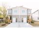 Modern townhomes featuring a light gray exterior with white garage doors and wood stairs at 109 S Plum St, Durham, NC 27703
