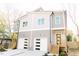 Two-story townhome featuring a light gray exterior with white garage doors and wood stairs at 109 S Plum St, Durham, NC 27703