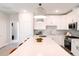 Bright kitchen boasts a large center island, modern appliances, white cabinets, and a stylish tile backsplash at 109 S Plum St, Durham, NC 27703