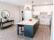 Bright kitchen boasts a spacious island, white cabinets, stainless steel appliances and stylish pendant lighting at 109 S Plum St, Durham, NC 27703