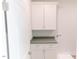 Convenient laundry room with sleek white cabinetry, gray countertops, and modern gold hardware at 109 S Plum St, Durham, NC 27703